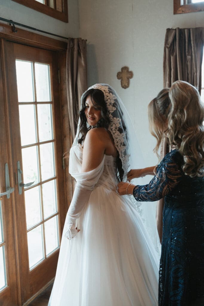 bride's mother zipping up her dress